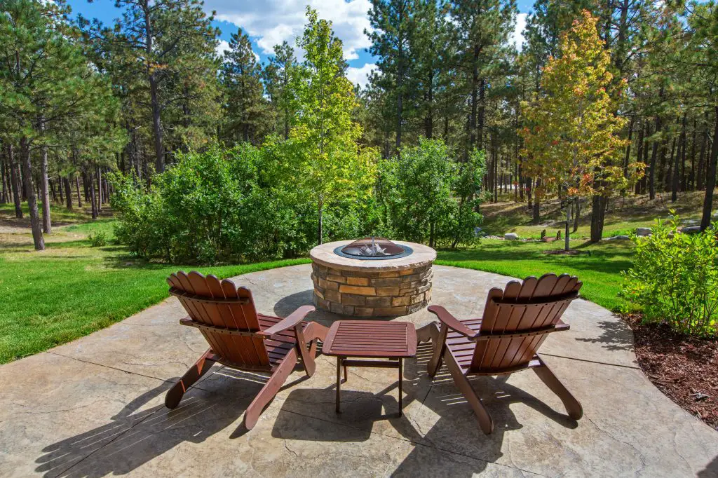 Fire pit with chairs in front of it. Fire pit has a liner.