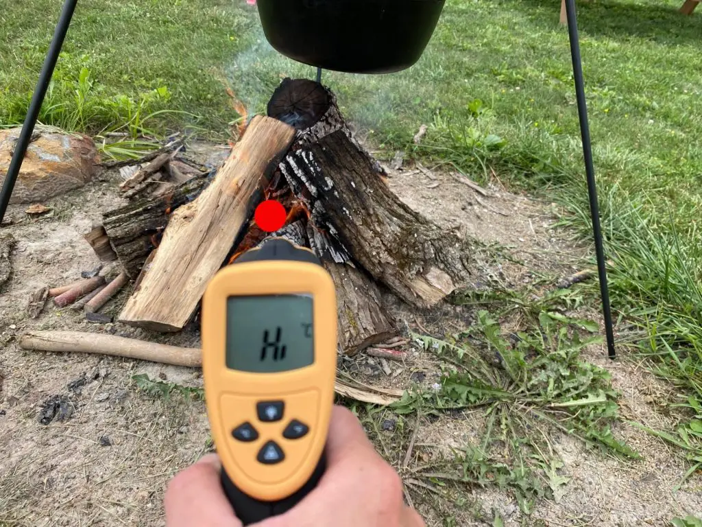 Infrared thermometer pointed at the center of a campfire and showing Hi, over 1400 degrees.