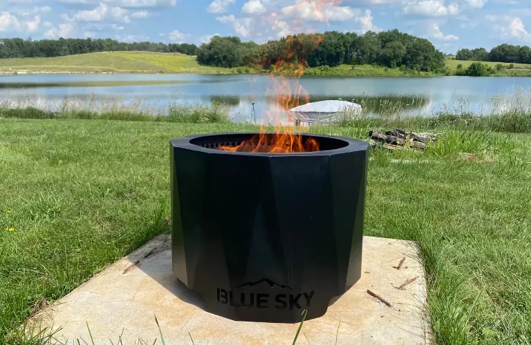 Blue Sky Outdoor Living smokeless Peak fire pit in front of a lake