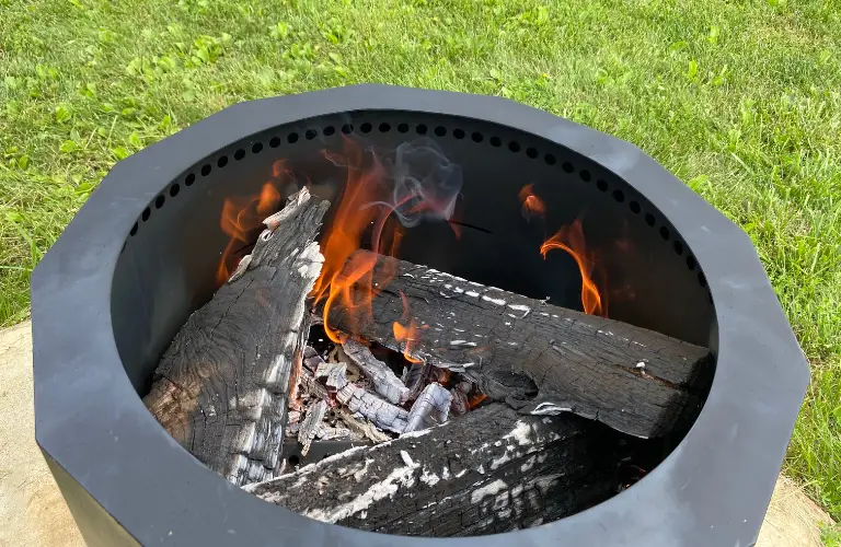 up close of wood burning in one of the fire pits and how much wood it can hold