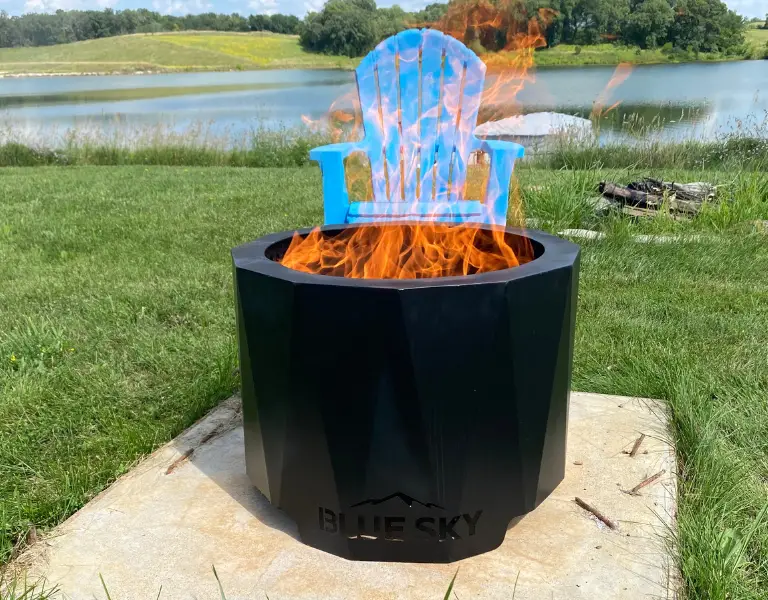 one of blue sky outdoor fire pits in front of a blue chair and lake