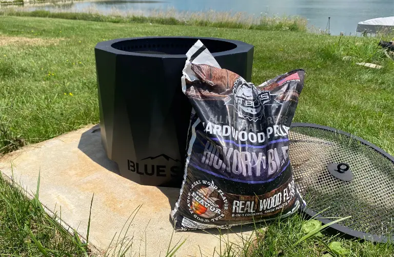 pit boss wood pellet bag next to one of blue sky outdoor fire pits