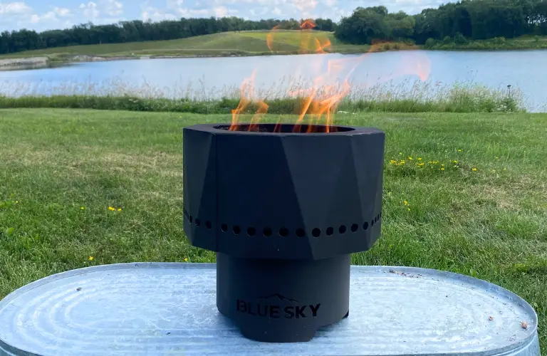 the pike ultra portable smokeless fire pit burning pellets in front of a lake