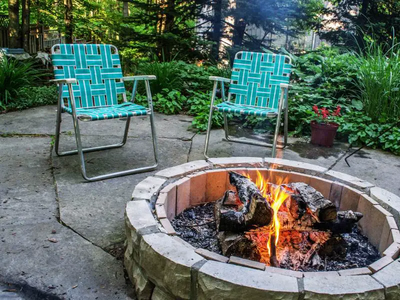 a diy fire pit with lawn chairs by it