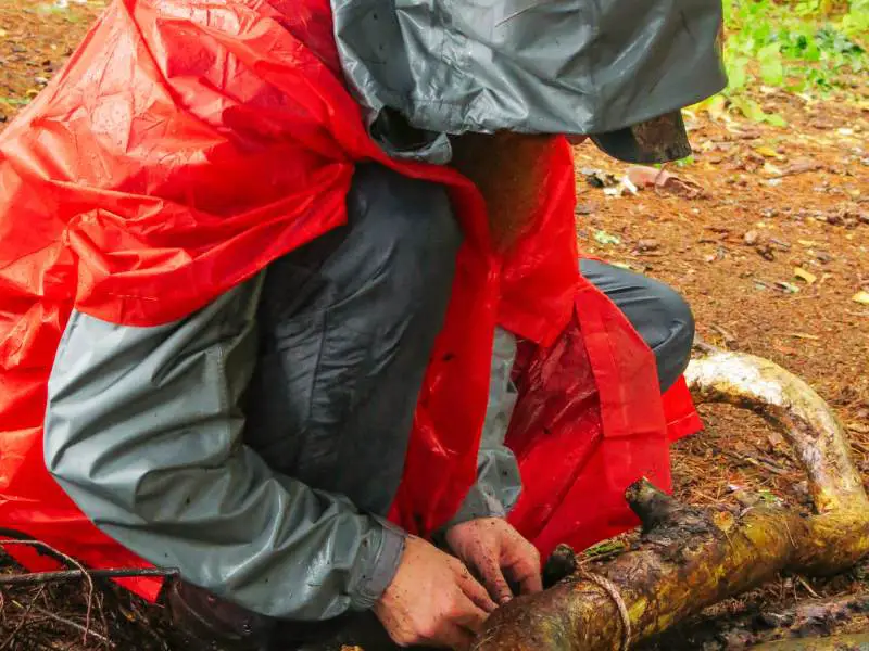 a person trying to start a campfire in the rain