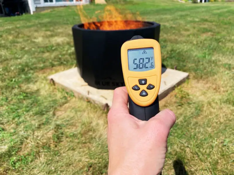 An infrared thermometer showing a reading on 582 degrees when pointed at the fire pit